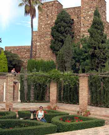 Young tourist sat in the gardens of the La Alcazaba fortress Malaga