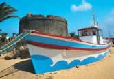 Costa Caleta boat on beach infront of Castle
